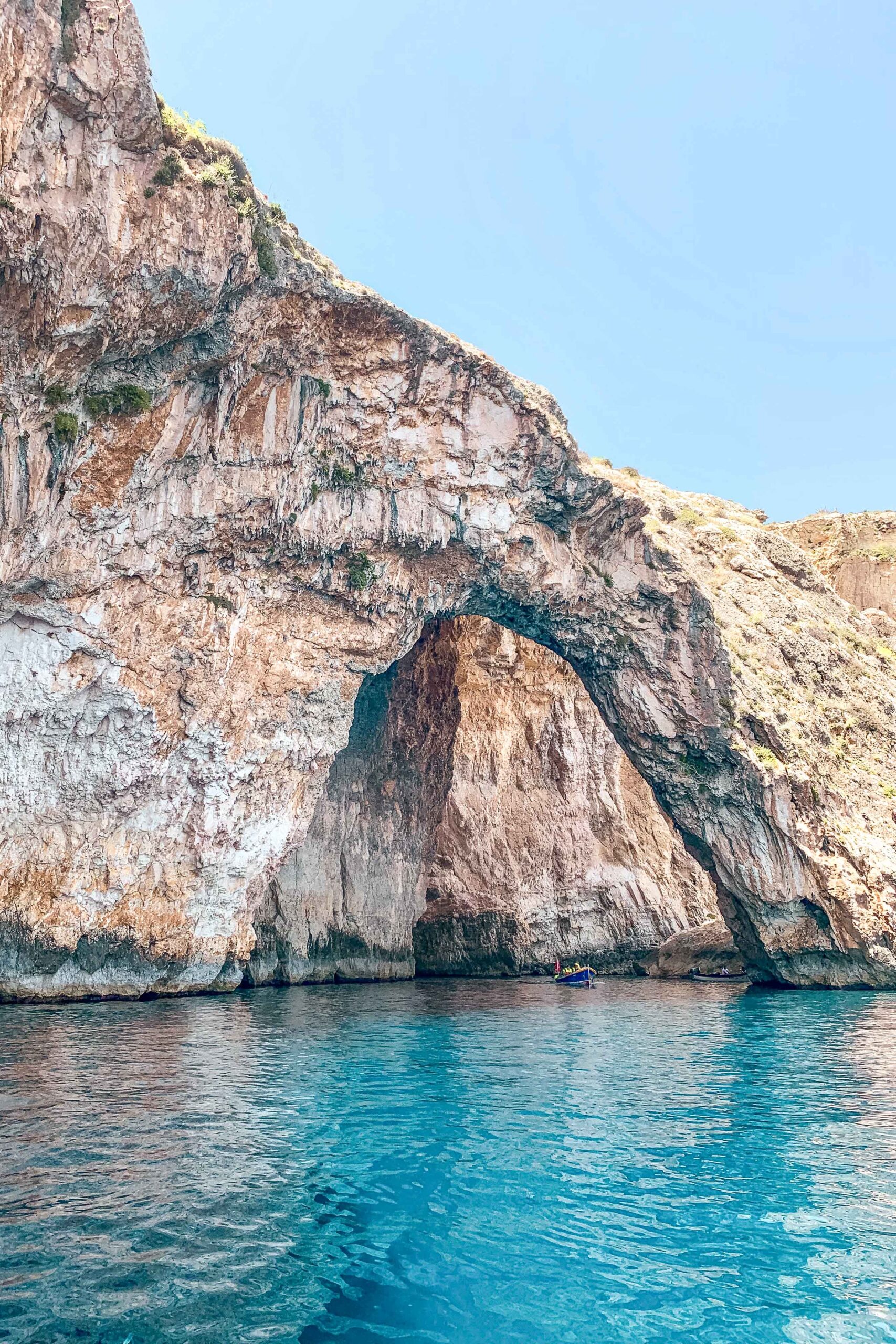 View of the Blue Grotto from the water with boat tour in Wied Iż-Żurrieq, Malta