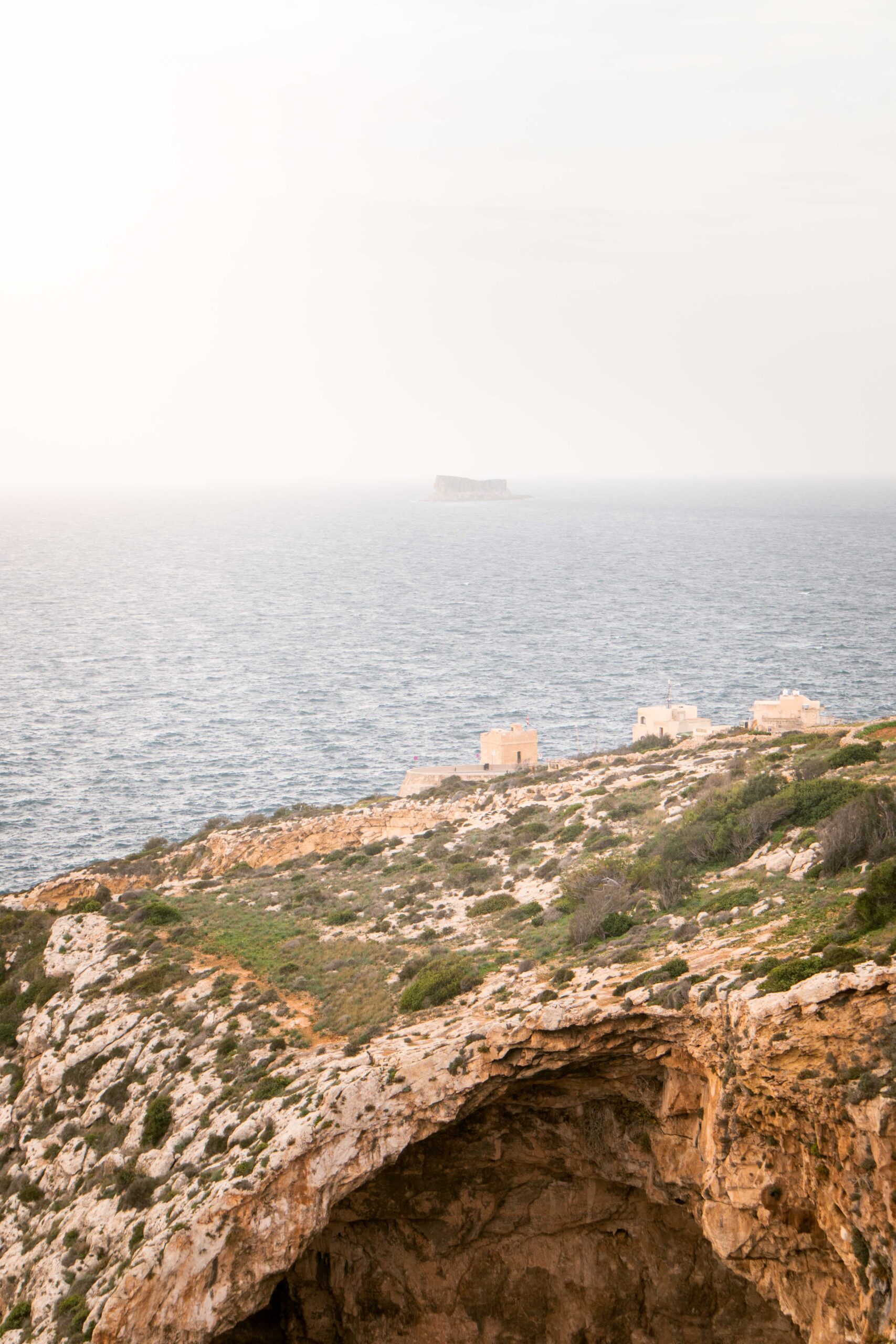 Top of the Blue Grotto and distant Filfla islet as seen from the Blue Wall and Grotto Viewpoint in Wied Iż-Żurrieq, Malta