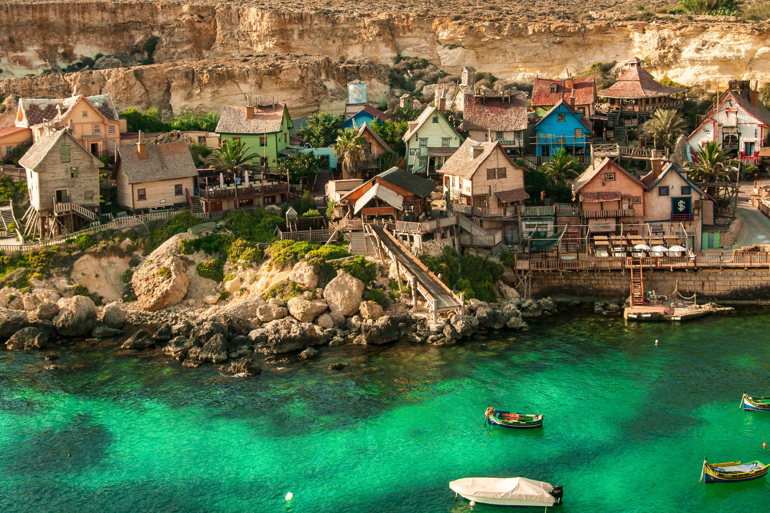 Popeye Village Park and traditional luzzu boats seen from Popeye Village Viewpoint in Malta