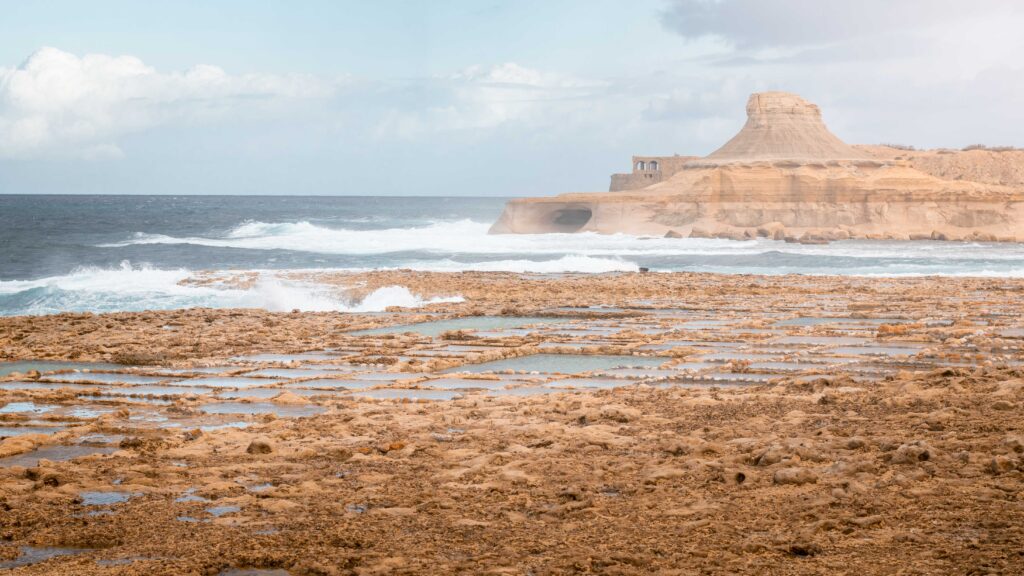 Agitated sea at Xwejni Salt Pans in Gozo island, Malta with a view of Xwejni Rock and Qolla l-Bajda