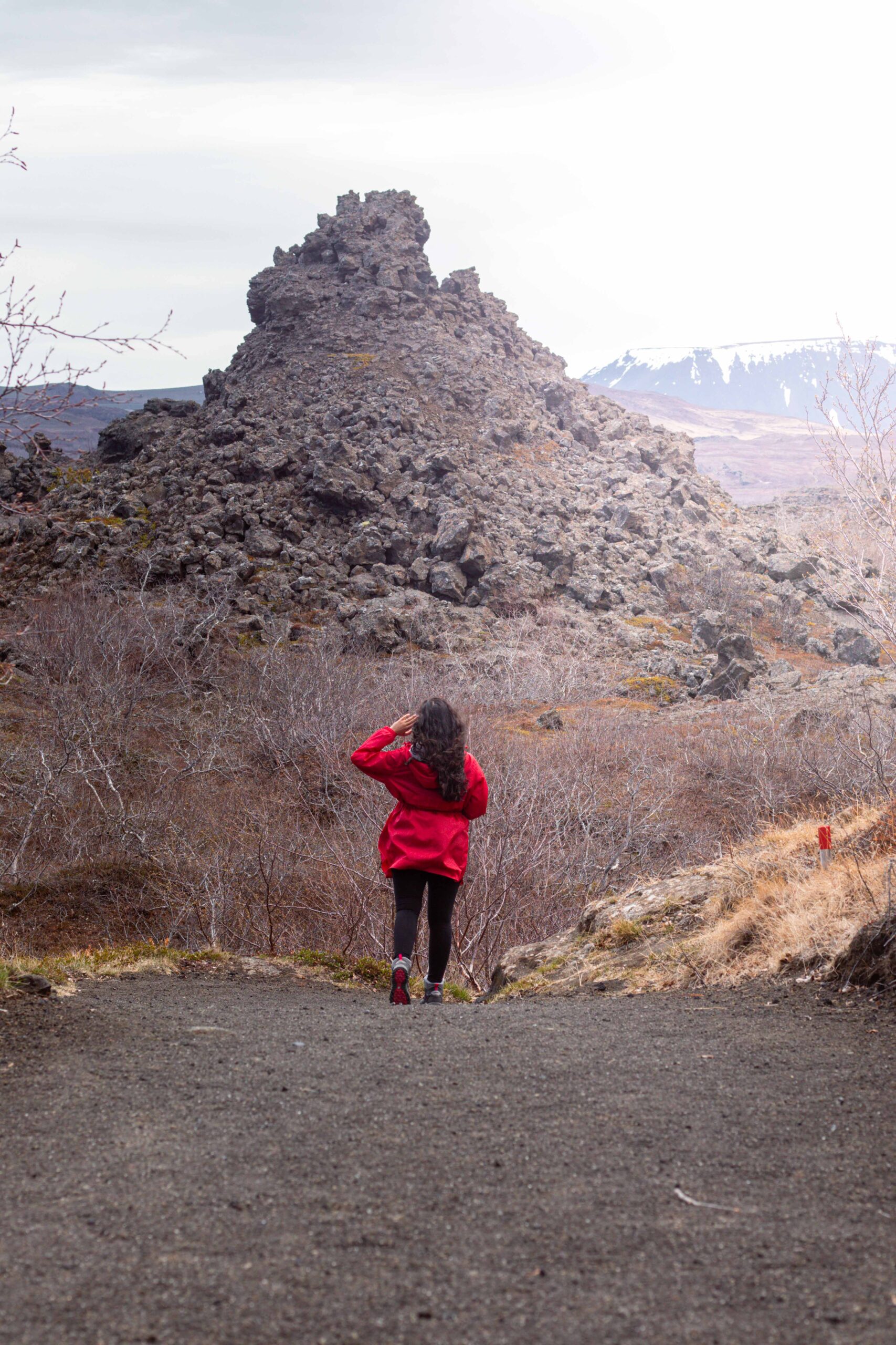 Woman hiking in Dimmuborgir lava fields at Mývatn Lake Area, North Iceland