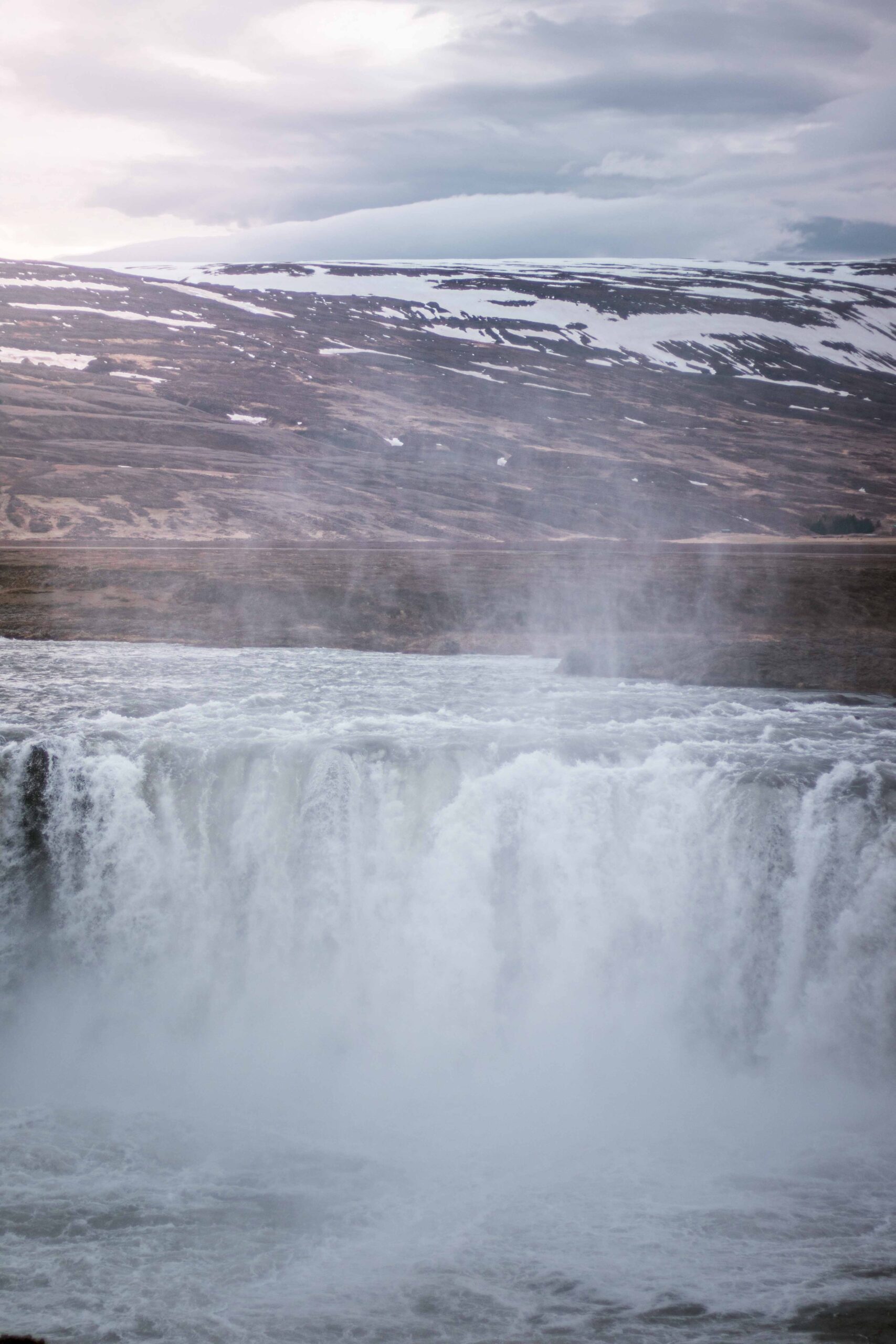 Strong water and mist of Godafoss waterfall seen from West bank, North Iceland