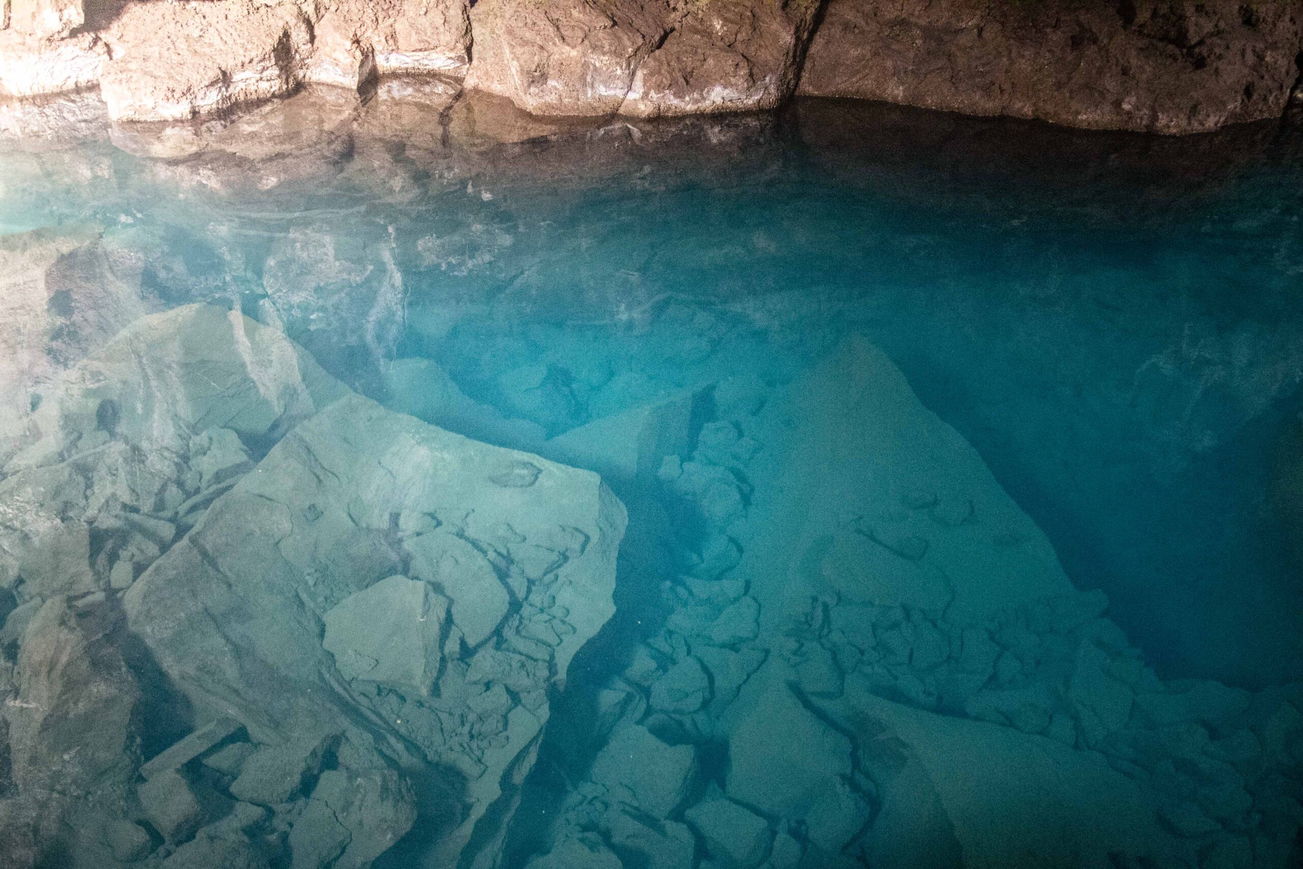 Rocks at the bottom of the hot spring pool in Grjotagja cave in Lake Mývatn area, North Iceland