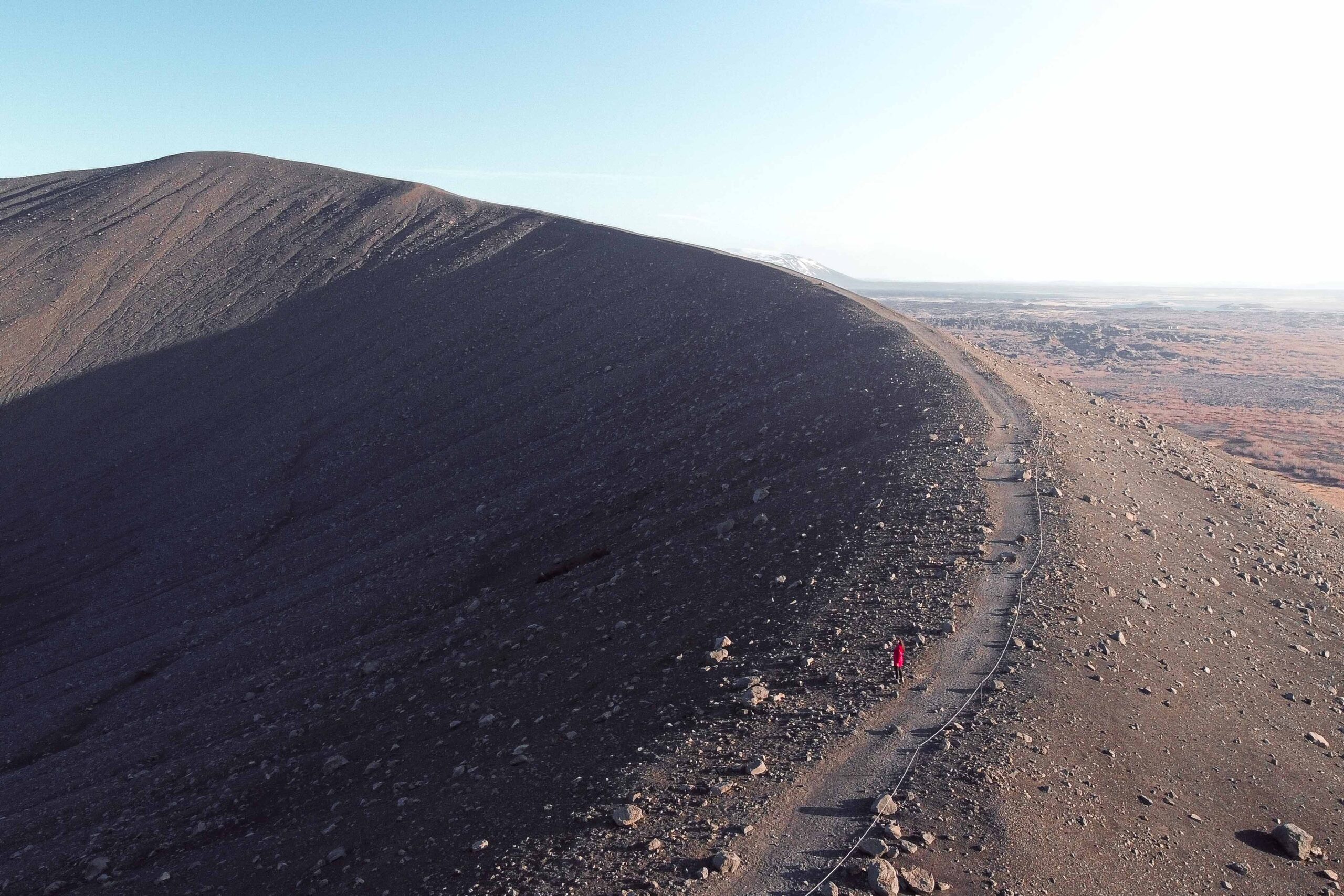 Drone view of a woman hiking on top of Hverfjall crater in Lake Mývatn area, North Iceland