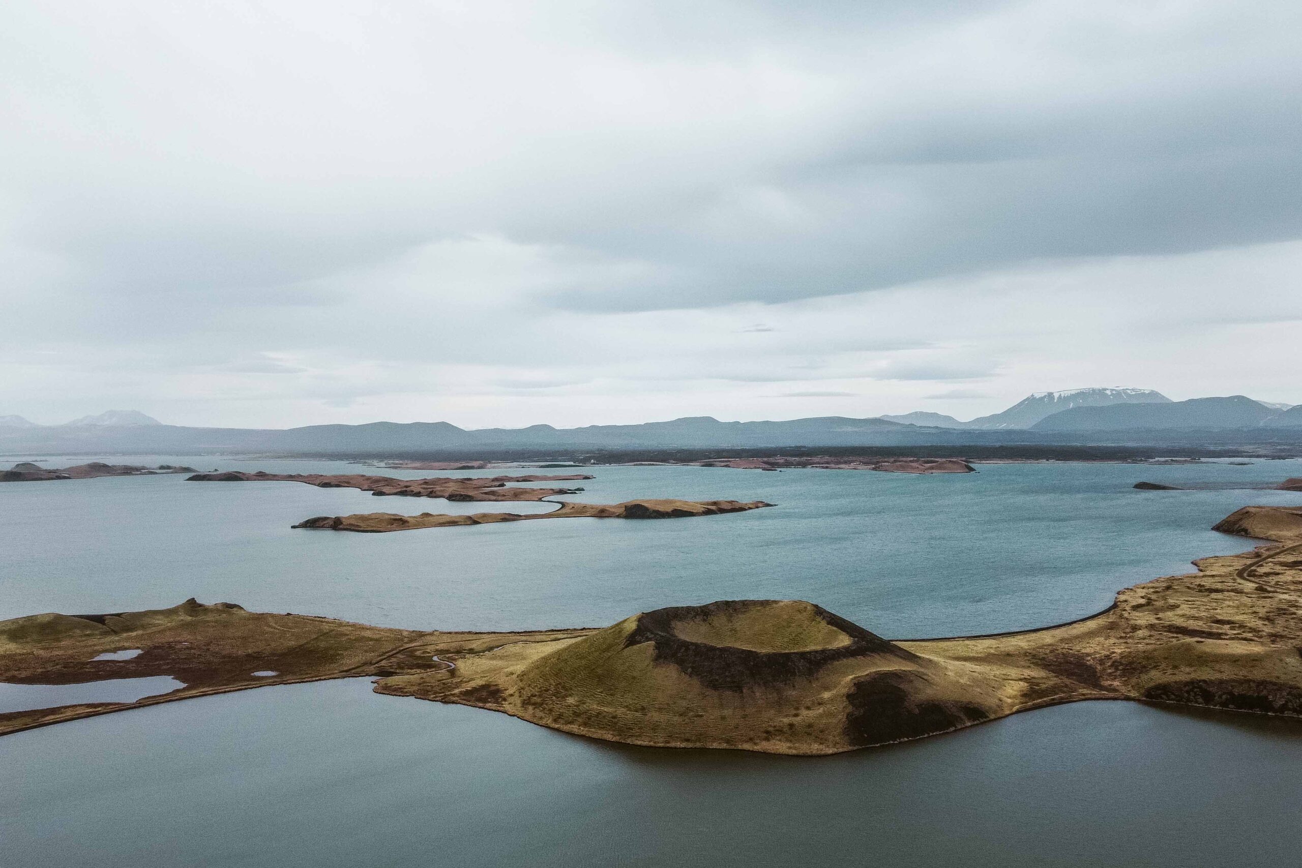 Drone view of pseudocraters and distant view of Hverfjall crater at Skutustadagigar in Lake Mývatn area, North Iceland