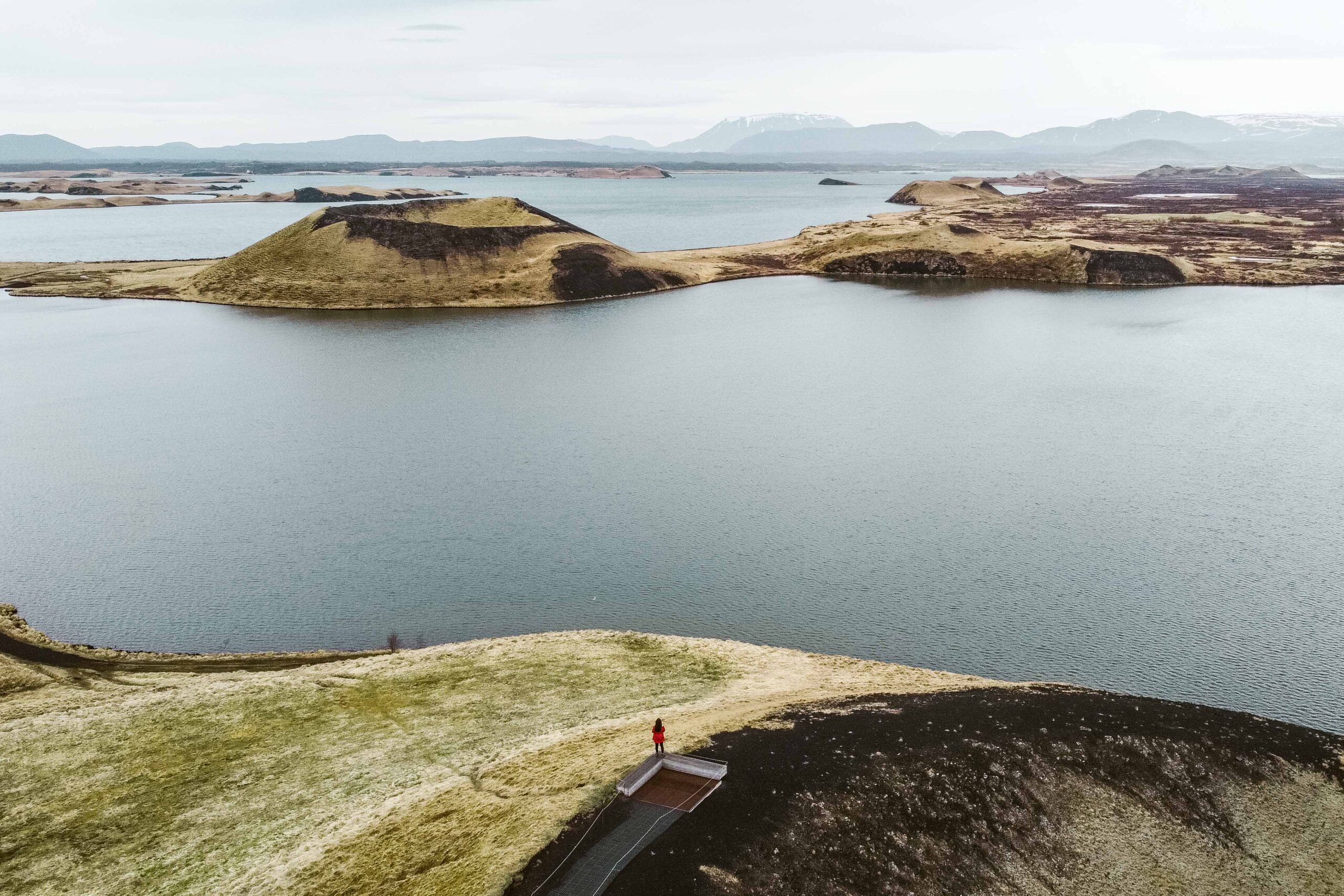 Drone view of pseudocraters and distant view of Hverfjall crater at Skutustadagigar in Lake Mývatn area, North Iceland