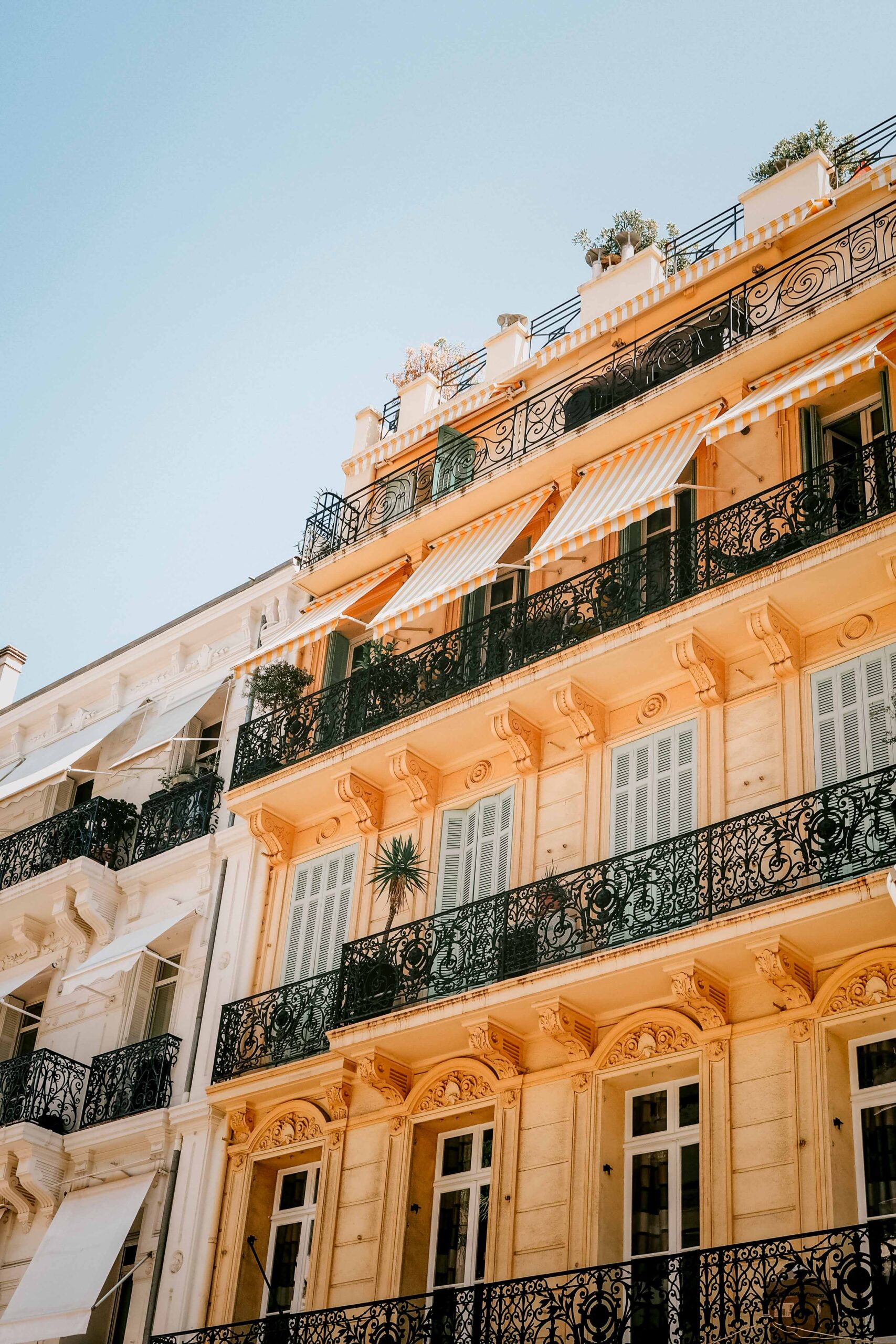 Details of the facade of a yellow fancy building as seen from the Boulevard de la Croisette in Cannes, France