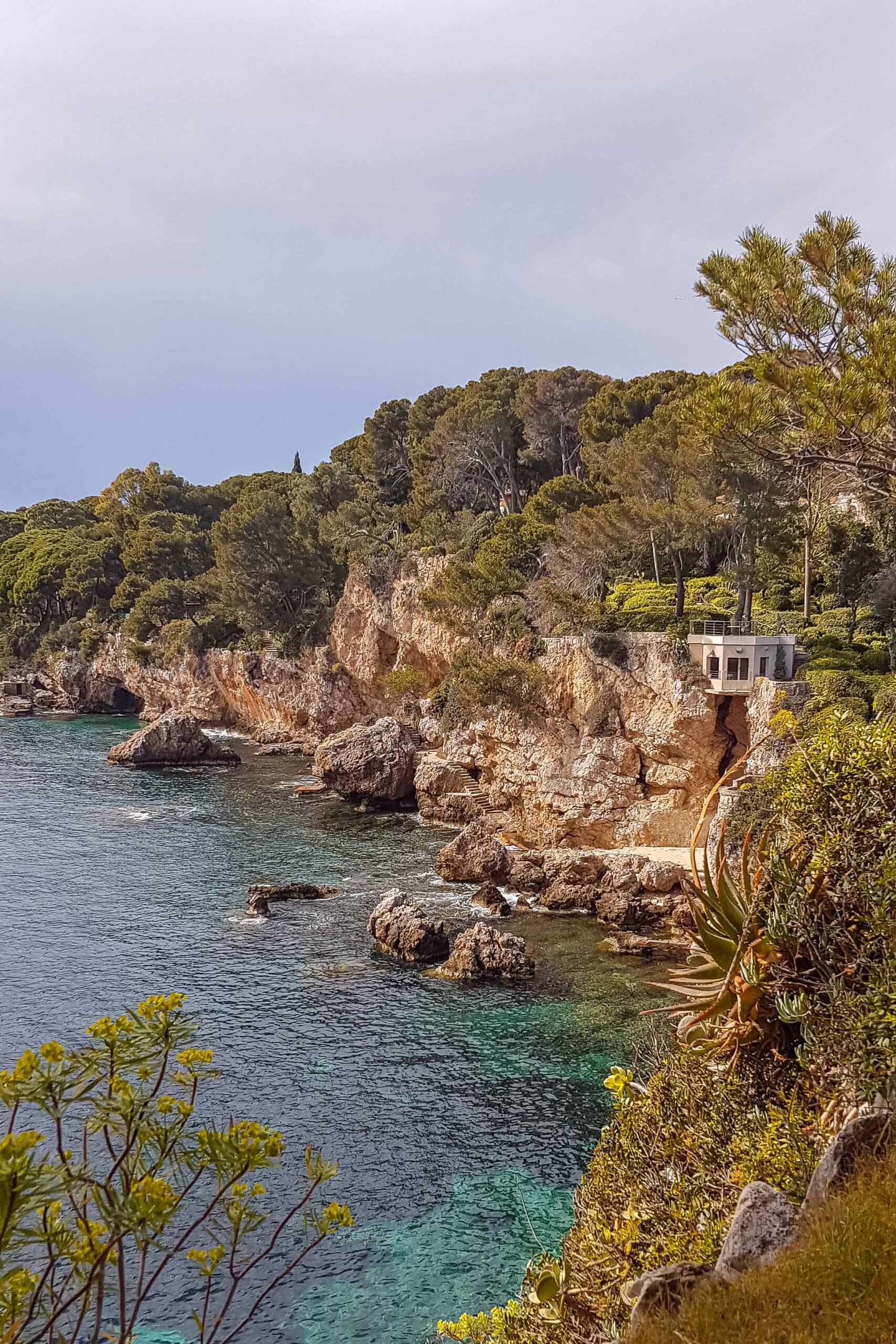 Rock cliffs and blue waters along the Sentier du Littoral hiking trail during a sunny day in Antibes, France