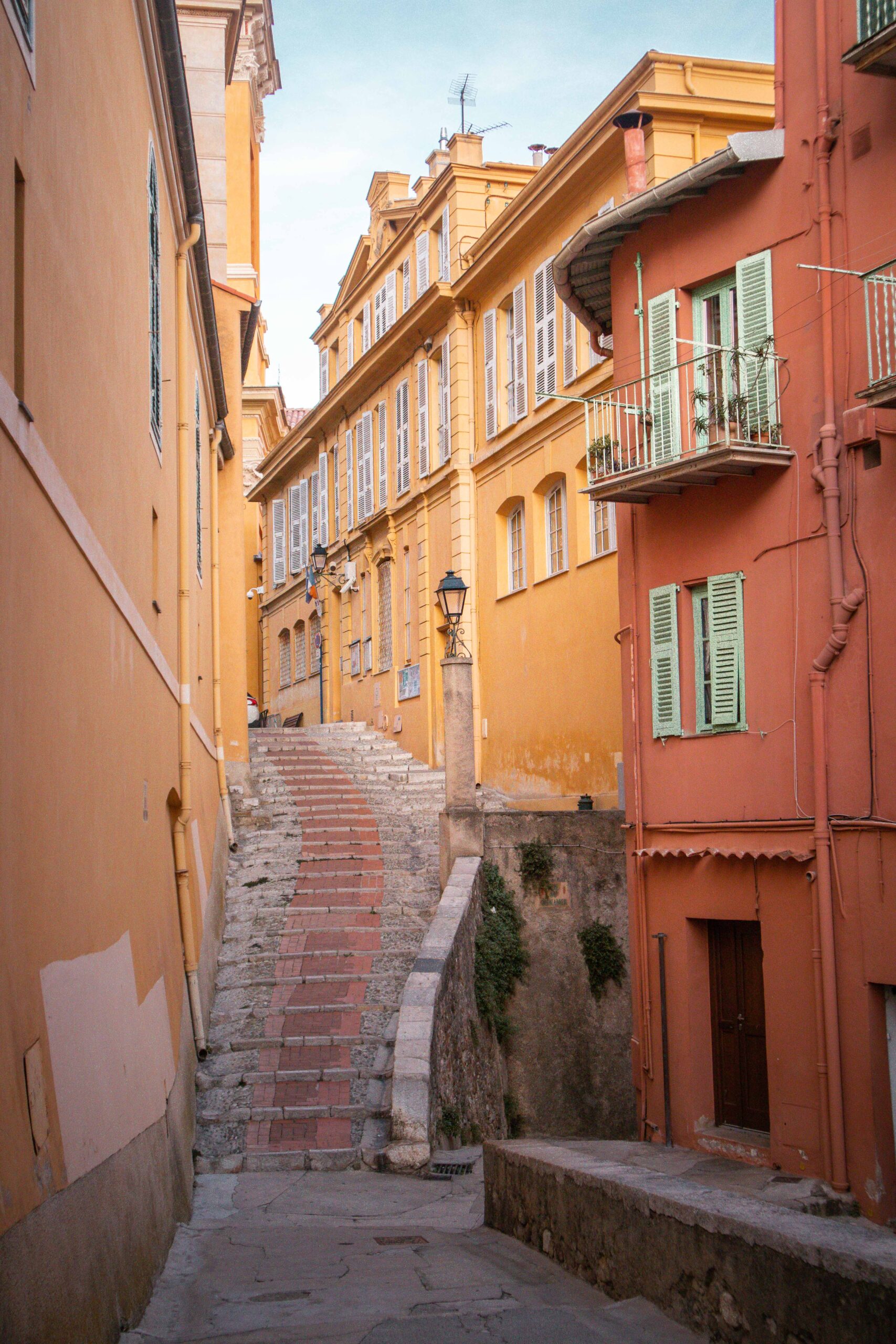 Staircase in a colourful street ("Rue du Palmier") located and leading to the Saint Michael Archangel Basilica in the Old Town of Menton, France