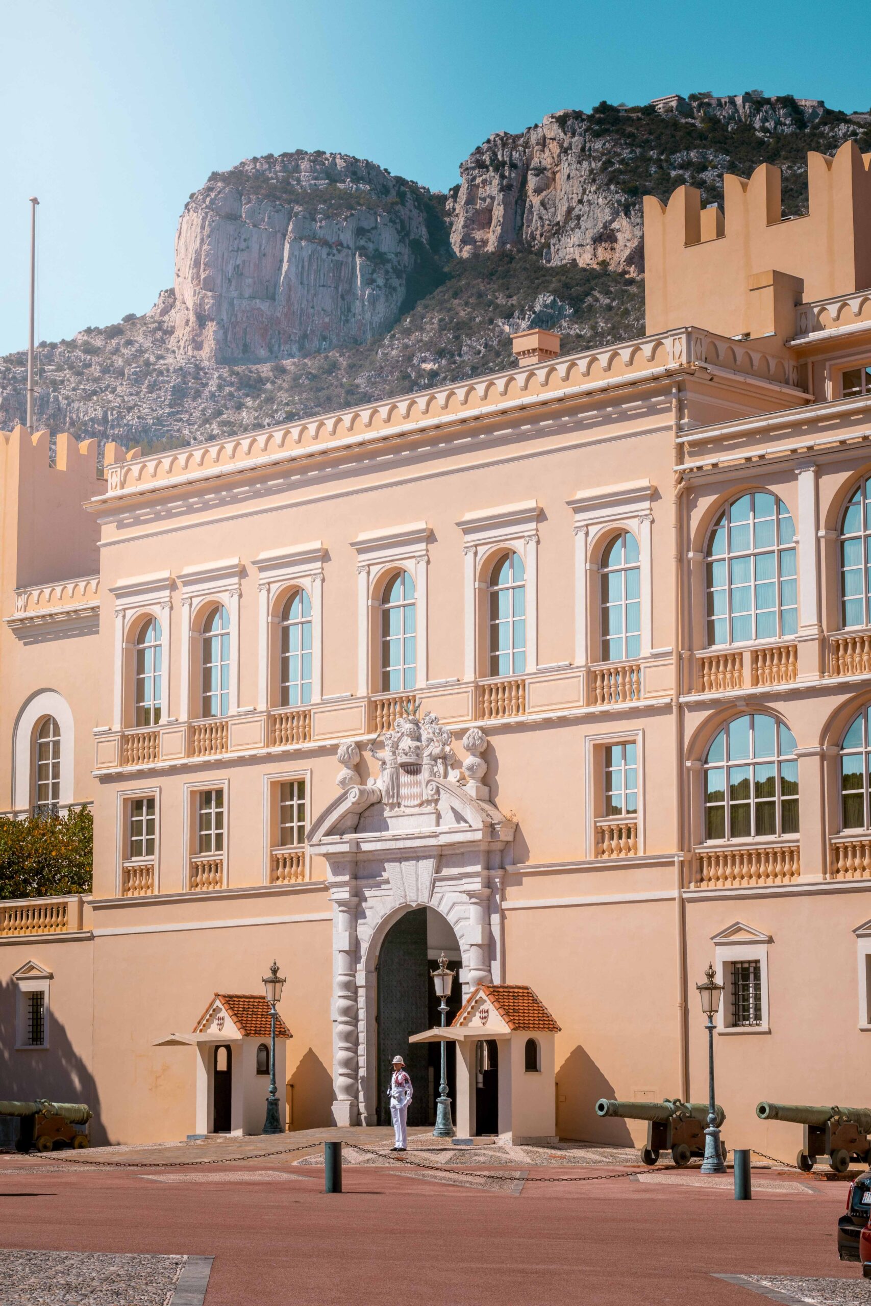 Facade of the Prince's Palace of Monaco, featuring a guard and cannons on a sunny day in Monaco