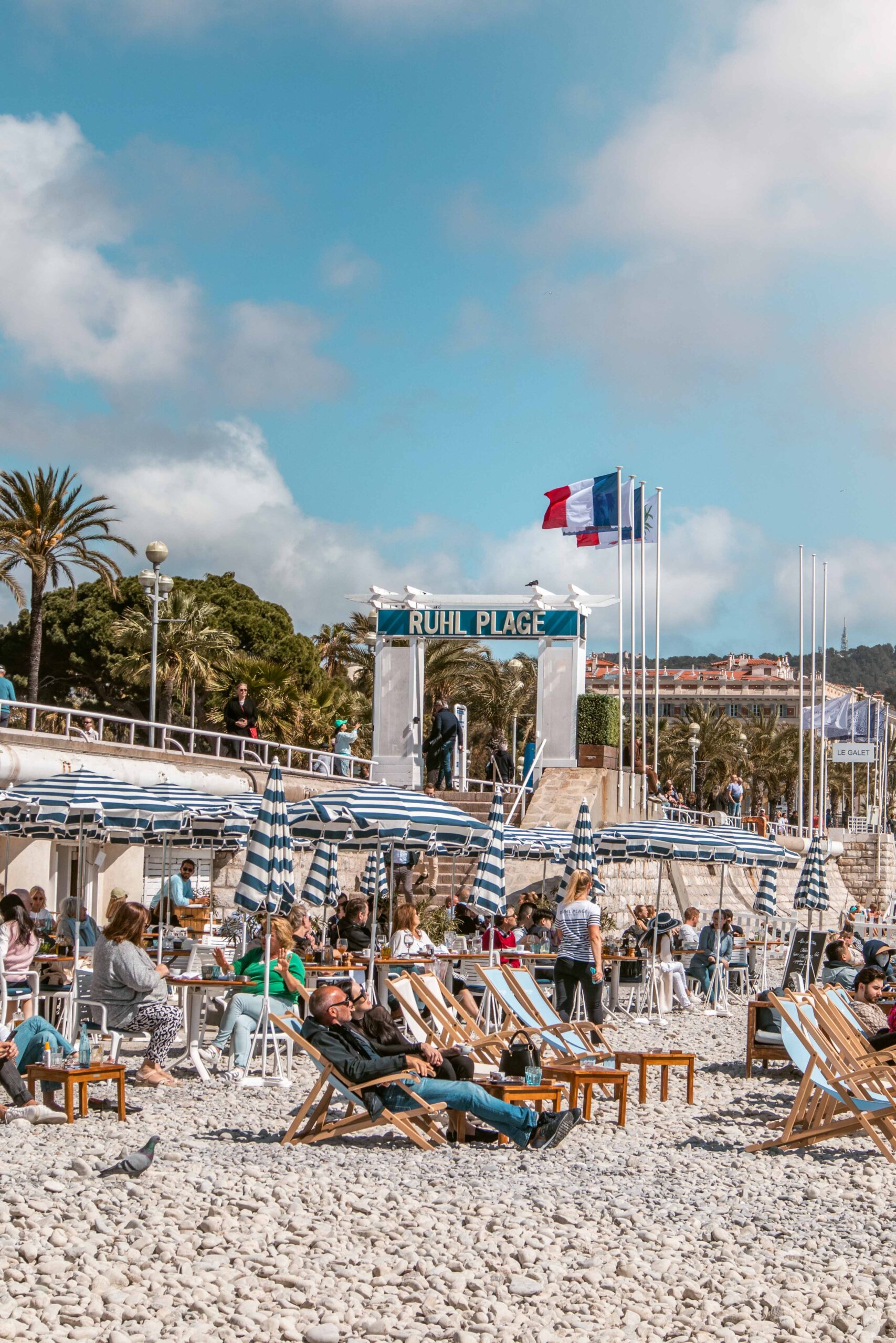 Deckchairs and beach umbrellas at the Ruhl plage as seen from the pebble beach along the Promenade des Anglais in Nice, France