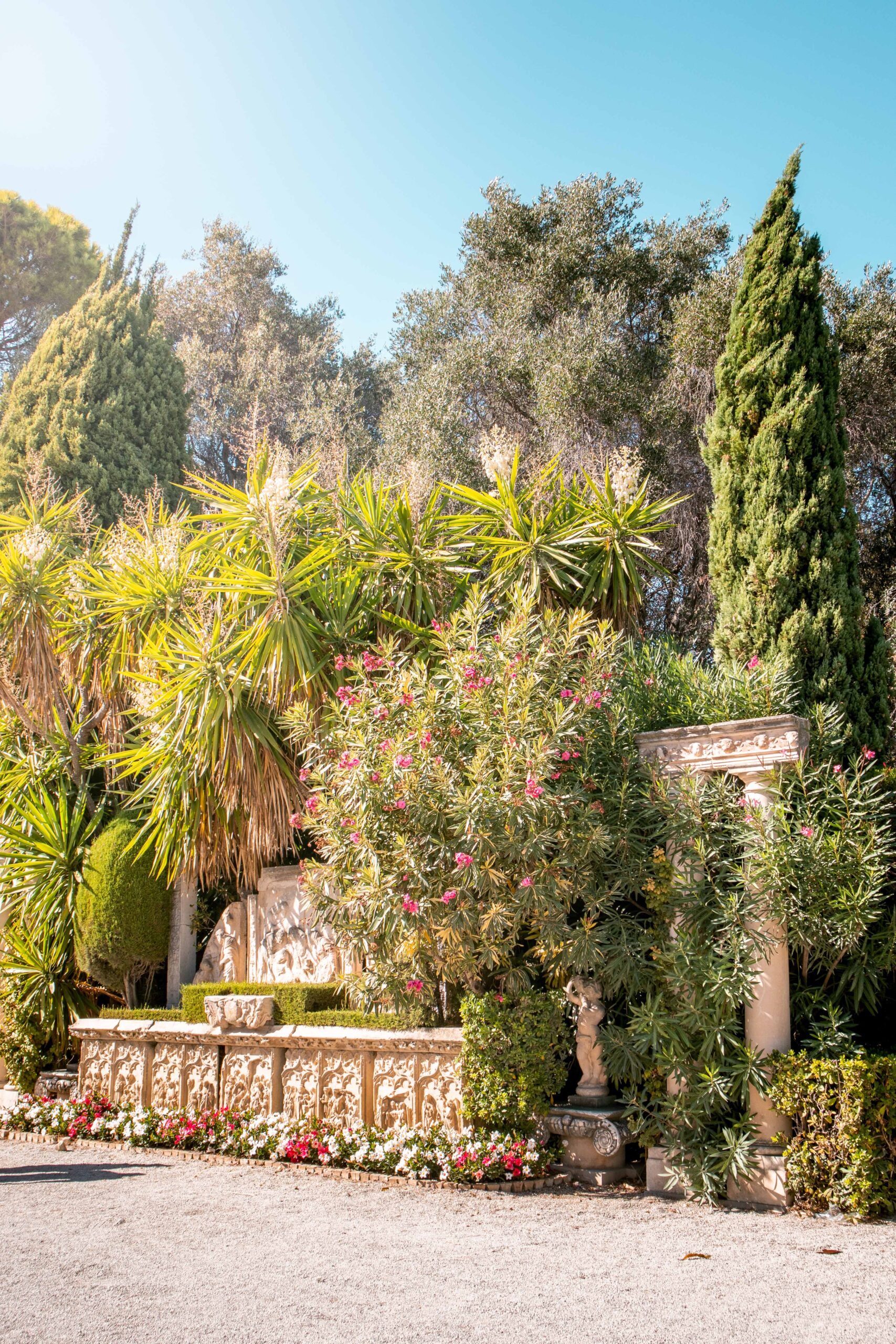 Details of the entrance of the Gardens and Villa Ephrussi de Rothschild with vegetation and Ancient Roman artworks in Saint-Jean-Cap-Ferrat, France