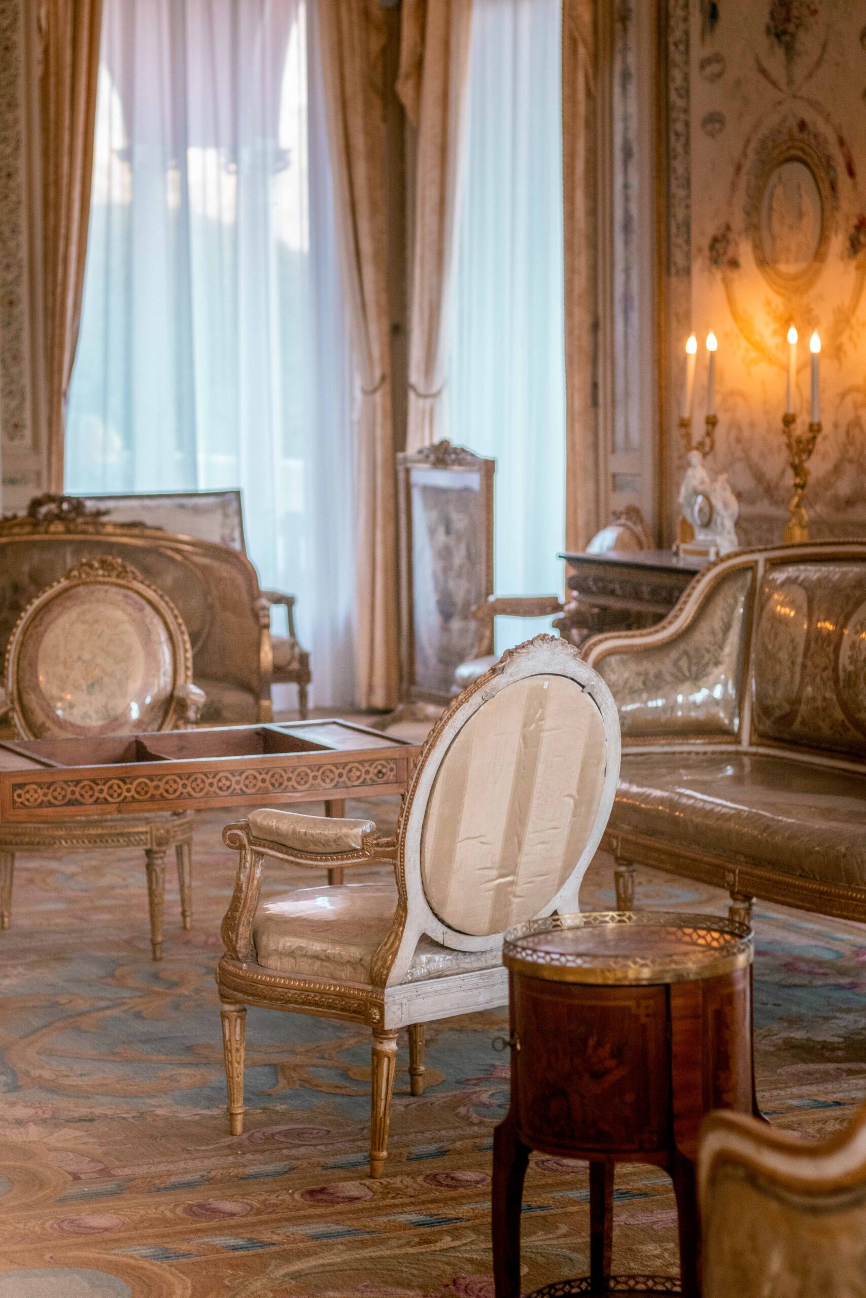 Indoor room of the Villa Ephrussi de Rothschild featuring baroque-style furniture (chairs, table, couch) in Saint-Jean-Cap-Ferrat, France