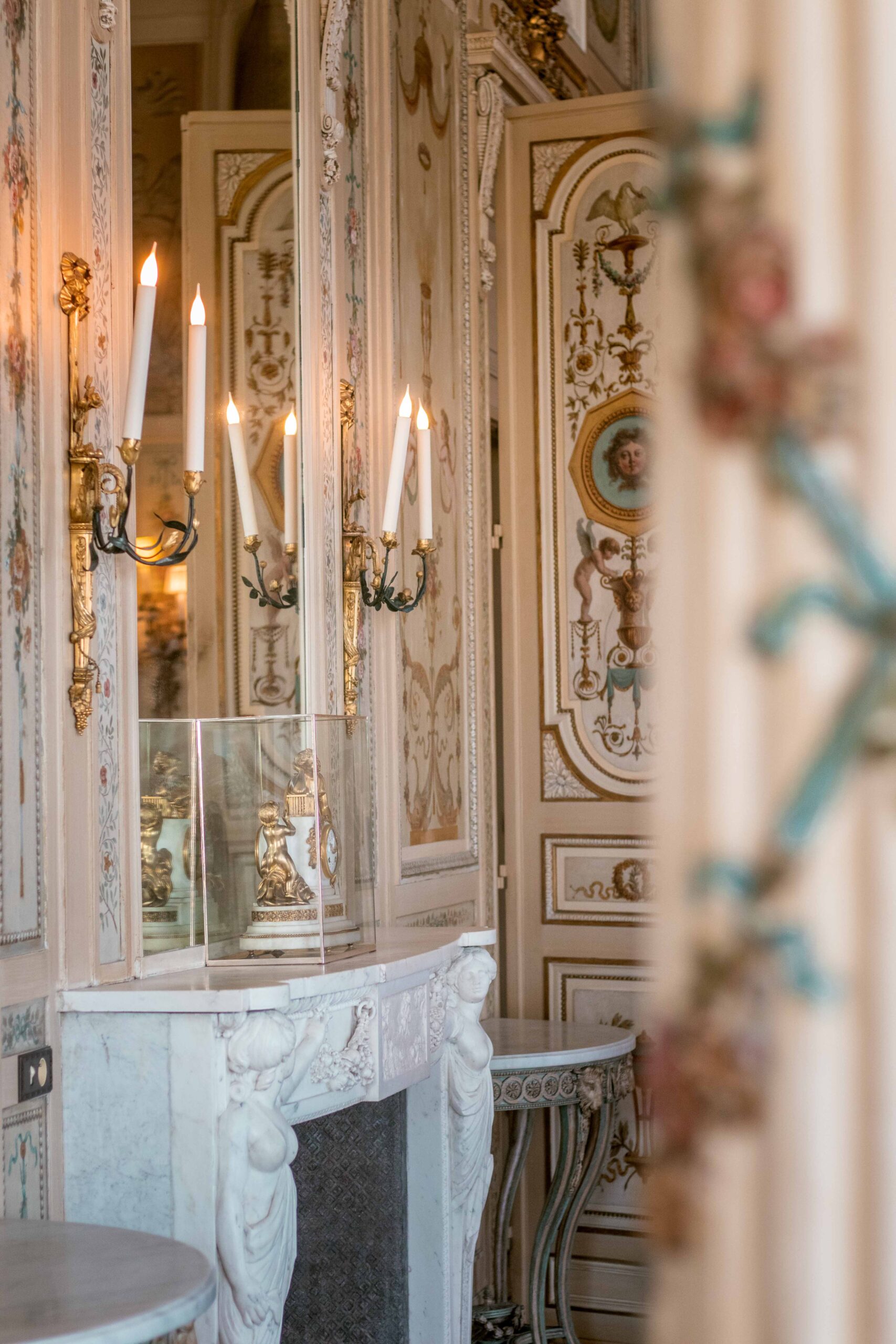Details (clock, candlesticks, mirror) over an indoor chimney and baroque-style tapestry of the Villa Ephrussi de Rothschild in Saint-Jean-Cap-Ferrat, France